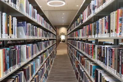 Shelves of books line the sides of a narrow walkway at Main.