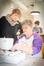 Elizabeth Adams oversees a patron with a sewing machine.