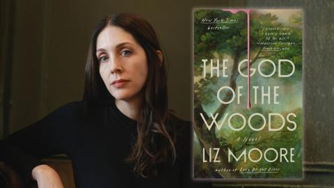 Author Liz Moore dressed in black, sitting next to the cover of her book, "The God of the Woods."