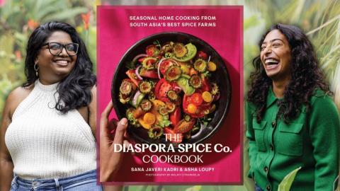 Authors Sana Javeri Kadri and Asha Loupy stand in a garden smiling. A cover of their book, "The Diaspora Spice Co. Cookbook" is placed in between them.