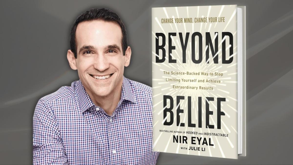 Author Nir Eyal sits next to a cover of his book, "Beyond Belief" in front of a gray background.